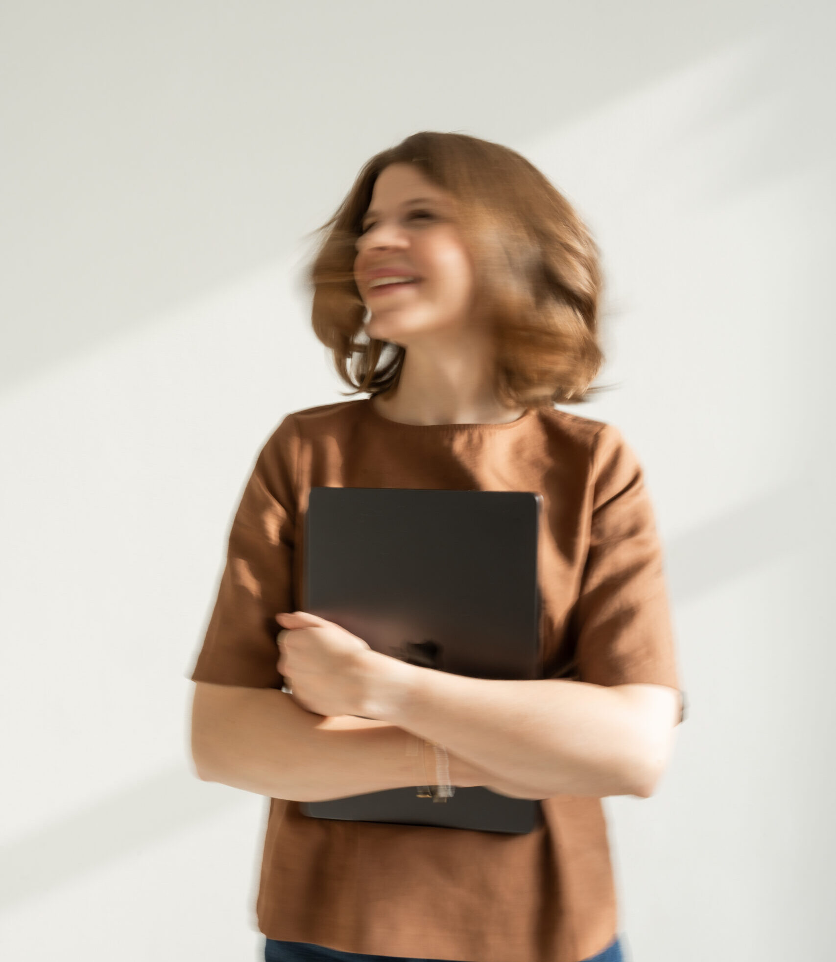lacourage-brand-designerin-laura-small Laura, Brand Designerin bei LaCourage, lächelnd mit Laptop im Arm