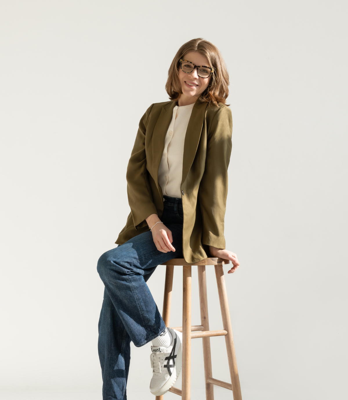 lacourage-warum-branding-small Laura, Brand Design, LaCourage, sitzend auf einem Hocker in einem Blazer, erklärt warum Branding so wichtig ist